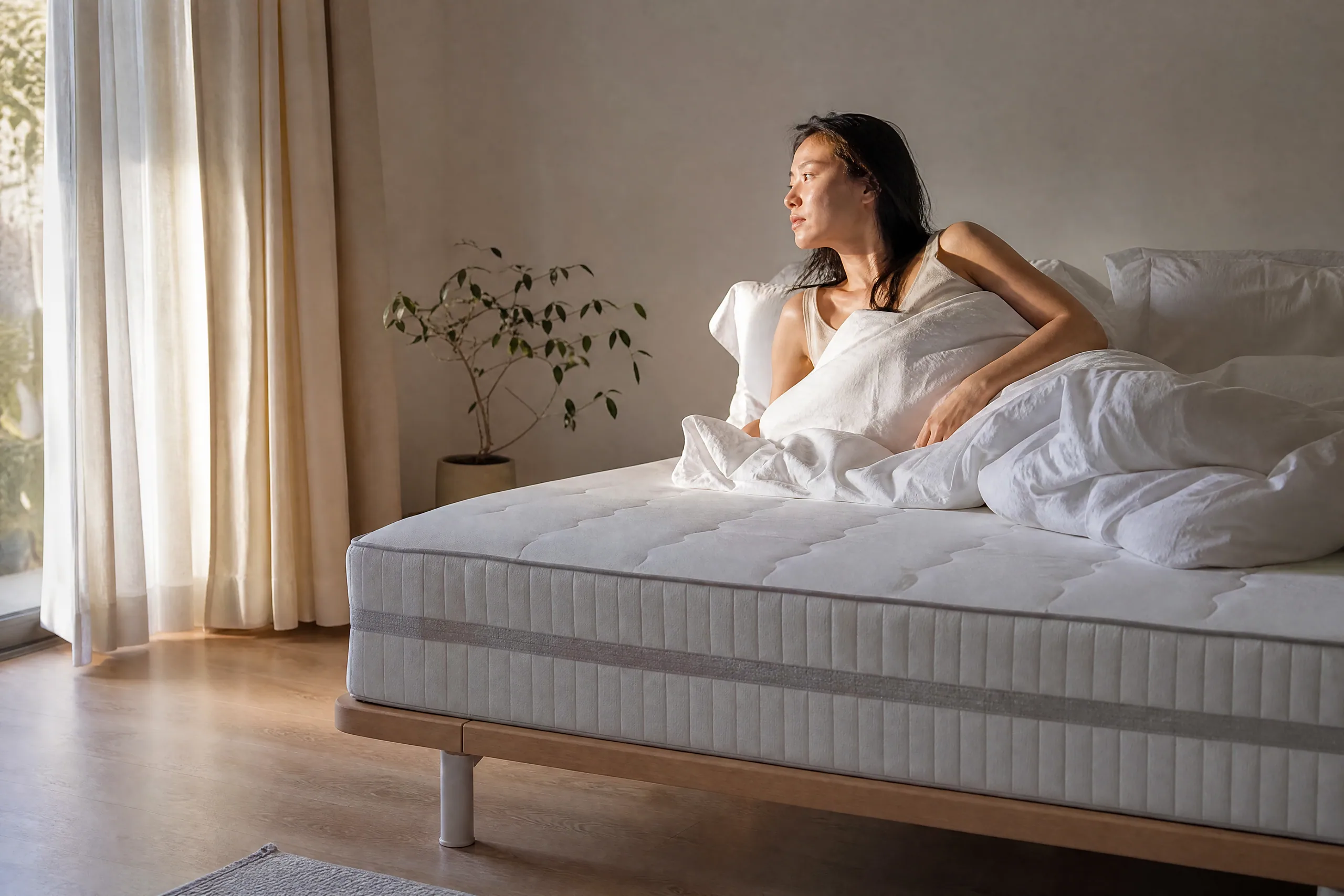 A woman waking in warm early light, eyes half open, no phone or clock in sight. (illustration)